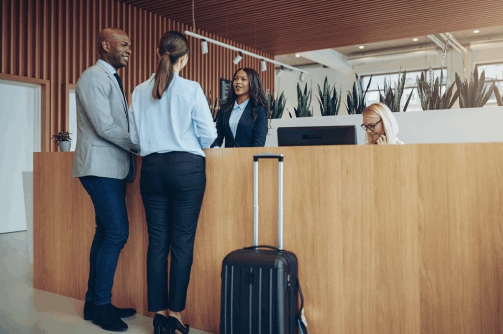 Man and woman checking into hotel reception desk