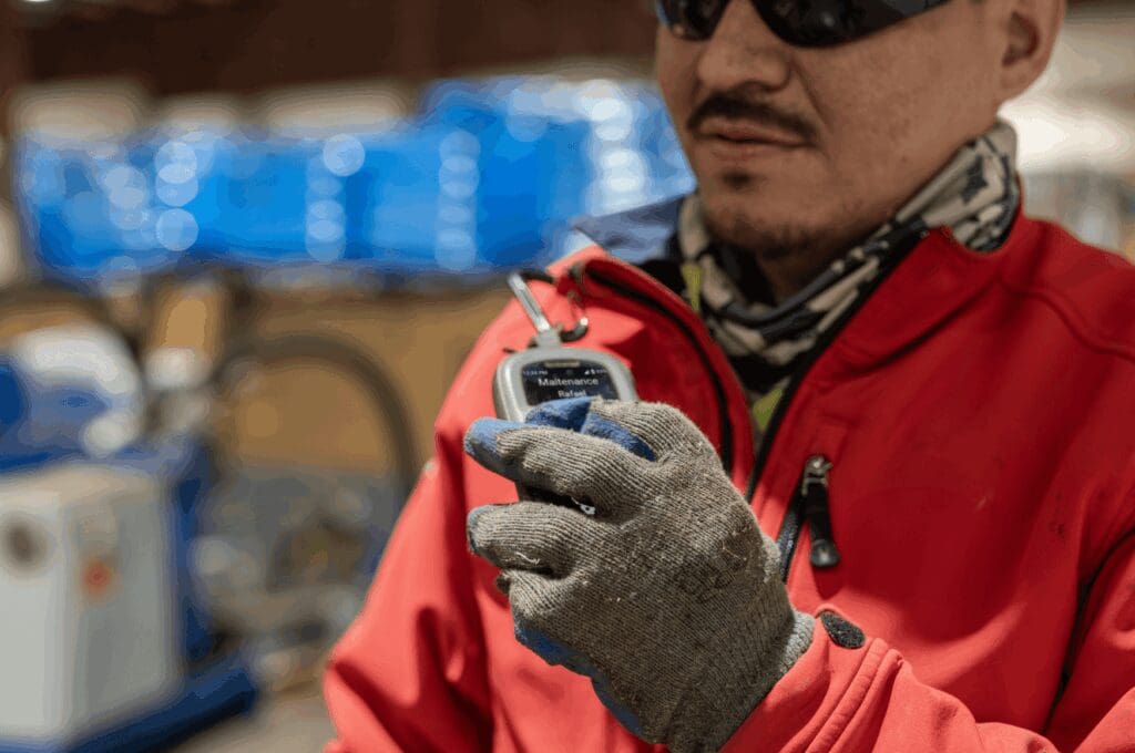 Man in red in industrial facility using relay radio for crisis management strategies