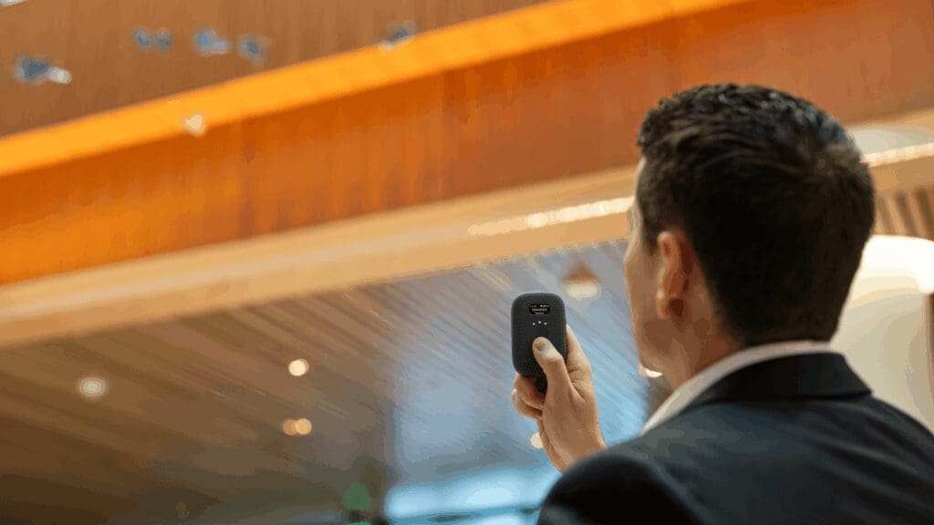 Man holding smart radio RelayM in hotel lobby