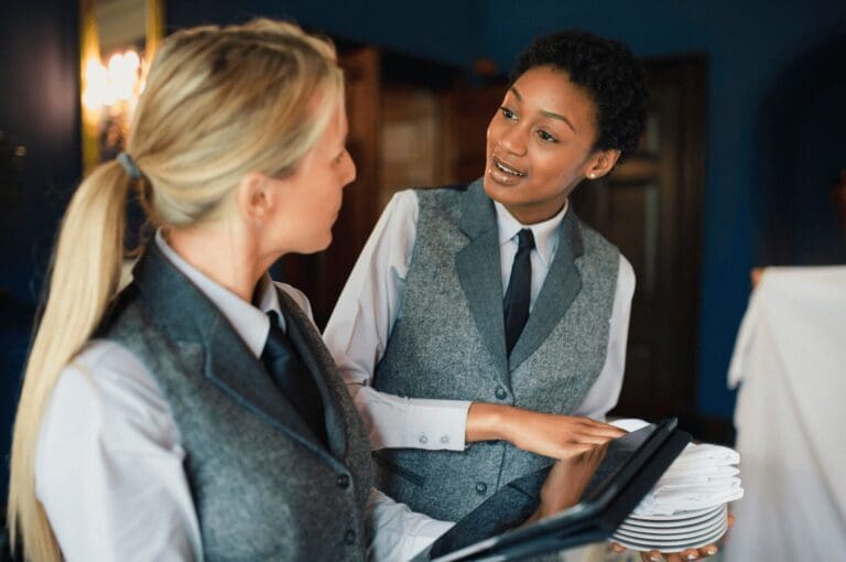 Two women discussing new technology in a hospitality environment