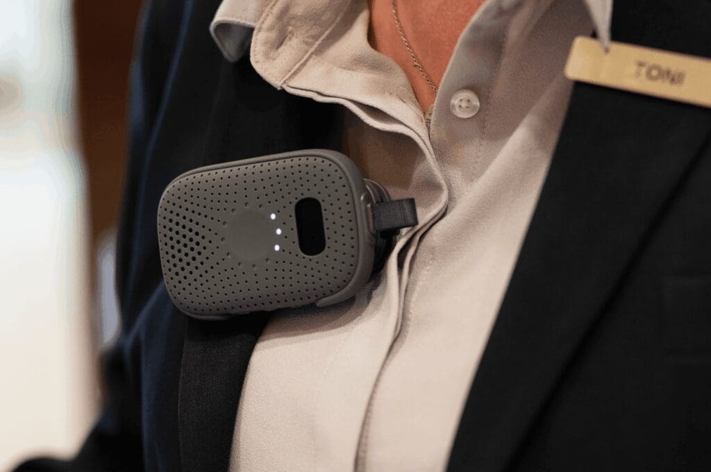 Hotel employee wearing RelayX as translation device on their navy blazer