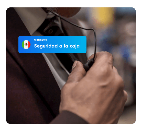 A suited casino employee wearing an earpiece hears the translated message in Spanish, “Seguridad a la caja.”