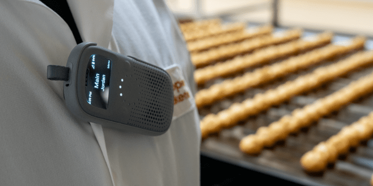 RelayX attached to a jacket in front of a cream puff production line.