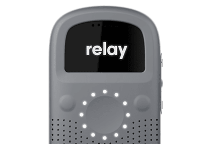 Close-up front view of a gray Relay communication device, showing the circular LED interface and screen displaying the Relay logo.