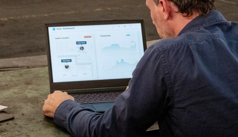 Man viewing Relay dashboard on a laptop, displaying indoor location tracking and productivity analytics.