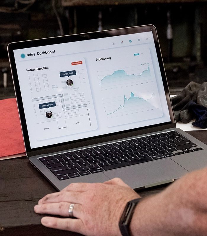 Laptop screen showing the Relay Dashboard with real-time indoor location tracking and productivity analytics.