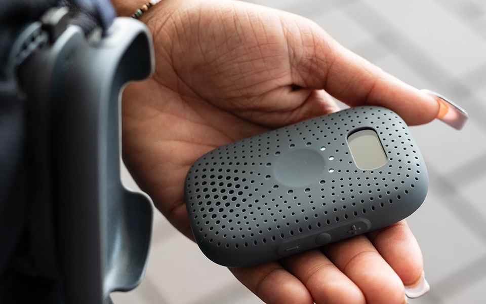 Close-up of a RelayM device in a staff member’s hand, ready for use.